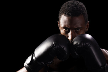 African American man in boxing gloves focuses intently