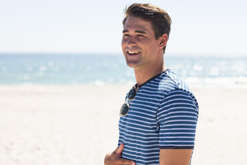 Young Caucasian man enjoys a sunny day at the beach, with copy space unaltered