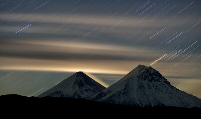 Star rain. Kamchatka, Natural Park Klyuchevskoy ("Valley of the giants").  Klyuchevskaya Sopka and Kamen volcanoes. Night, moonlight, long exposure