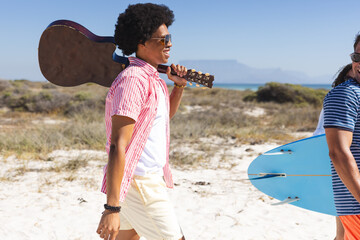 A diverse group of young friends enjoys a sunny beach day unaltered © WavebreakMediaMicro