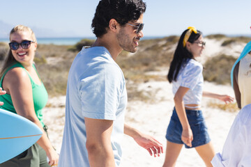 Fototapeta premium A diverse group of young friends walking to the beach, embodying the spirit of summer with their cas