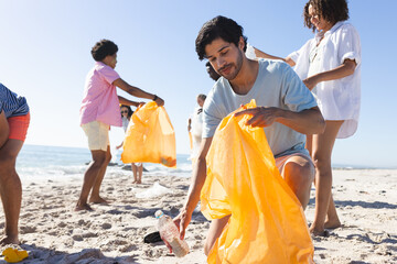 Diverse friends, a group of people, clean a beach by collecting trash