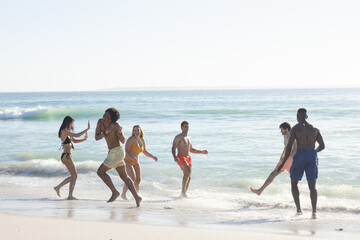 Diverse group enjoys a sunny beach day, with copy space