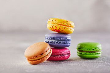Assorted colorful macaroons folded and arranged on a gray surface