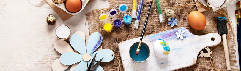 Easter DIY. Easter preparation, multi-colored paints and a brush for decorating eggs. Creativity...