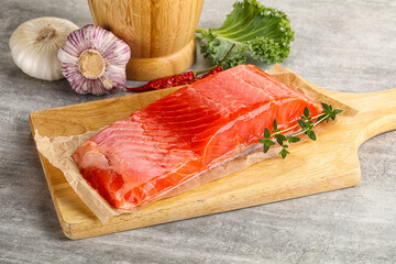 Raw salmon fillet over board