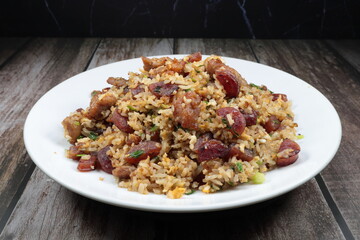 Stirred rice with Chinese pork sausage, egg and spring onion serving on the plate. Famous rice menu in Asian restaurant. Classic breakfast menu concept.