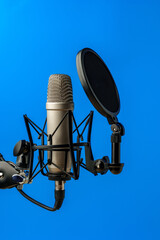 Professional microphone stand over blue studio background