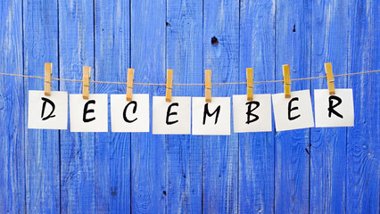 Word December. Month of December. Letters on cards on a wooden blue background. Winter. Cold and...