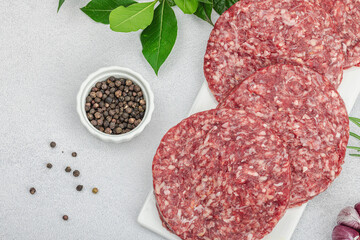 Raw burger patties. Fresh meat cutlets, spices, vegetables, herbs. Homemade American classic