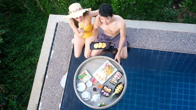 Top view girlfriend feed bun to boyfriend and spend time together at poolside and chill out concept