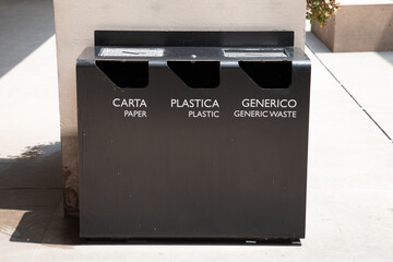 three gray trash cans with generic waste and recycling paper plastic in english italian language