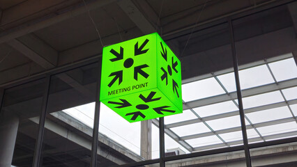 Meeting Point sign at a building. Positioned near the entrance, it serves as a visual cue, steering individuals towards the central meeting area