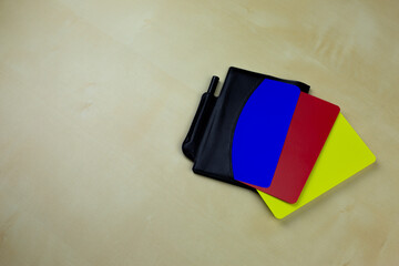 Notebook of football referee with red, yellow and blue cards