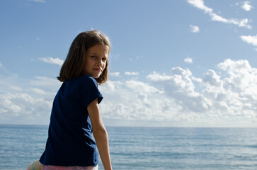 Fototapeta na wymiar Girl on the shore admiring the ocean