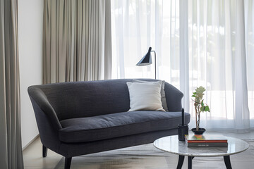 Elegant living room interior with a sofa, a lamp and a table close to a window for natural light