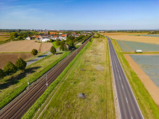 Railroad line and road in the countryside run parallel from drone shot