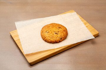 Oatmeal cookies with chocolate. On a wooden board.