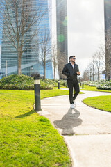 South American man walking in the park, drinking coffee. 
