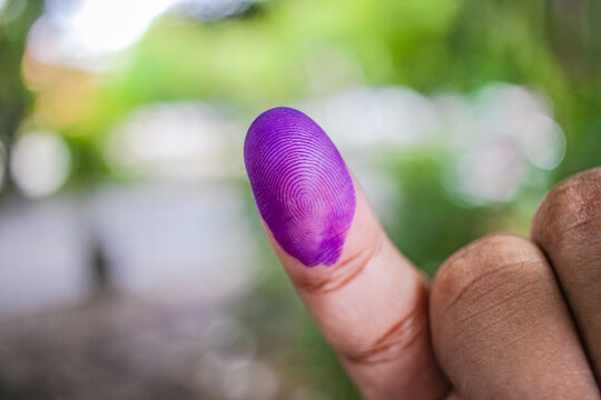 a picture of a man's hand. The ink on a man's finger was obtained after voting during the regional elections (pilkada) in Semarang, Indonesia