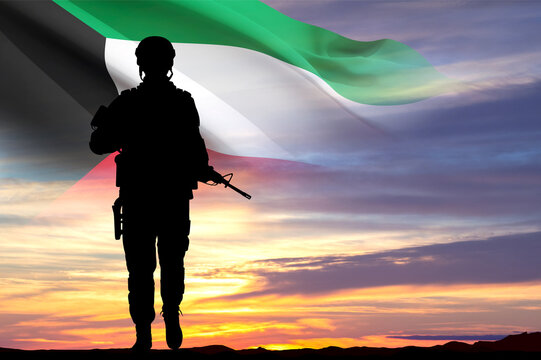 Silhouette of soldier with Kuwait flag against the sunset. Kuwait National Day. February 25-26.