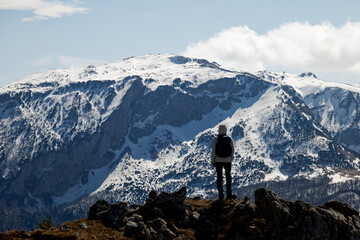 A woman admiring the mountain landscape. Hiking in the winter. Snow in the mountains. Travel and free spirit feeling.