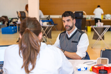 Man and nurse talking in a blood donation campaign center