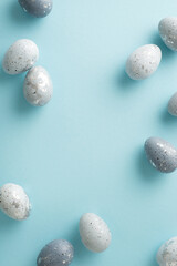Seasonal grace: Top-view vertical photo showcasing refined dove-grey eggs arranged neatly on a...