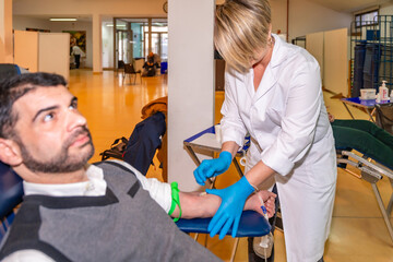 Female doctor preparing a patient for blood donation