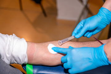 Nurse extracting needle from arm and cleaning the area