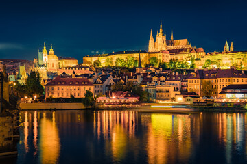 Fototapeta na wymiar Spectacular night view from Charles Bridge of Prague Castle and St. Vitus cathedral on Vltava river. Illuminated spring cityscape of Prague, Czech Republic, Europe. Traveling concept background..