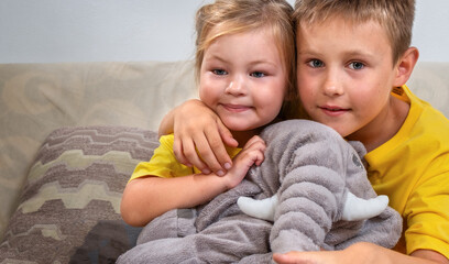 Fototapeta na wymiar Portrait of children sibling on the sofa with a toy
