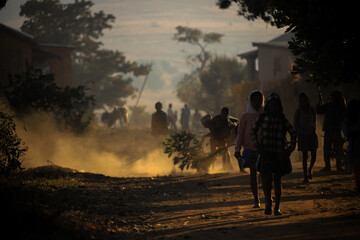 silhouette of schoolkids clean the street with a broom