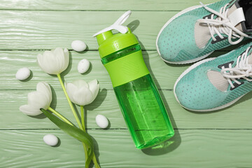 Green bottle for water, with flowers on a green background.