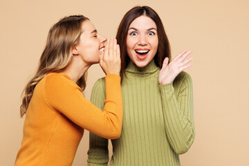 Young friend two women they wear orange green shirt casual clothes together whispering gossip and...