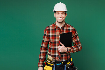 Young employee laborer man wear red shirt hardhat hat work hold clipboard with paper documents...