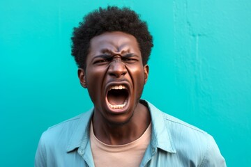 African American man, his stance aggressive, lips curled in a snarl, reacting to a confrontation on the street, captured against a solid pastel turquoise background. - obrazy, fototapety, plakaty