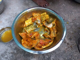 Raw cut Fish pieces,Raw cut Fish pieces mixing turmeric oil salt a woman hand on,Cutting raw fish on an Aluminium container,