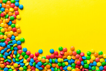 Mixed collection of colorful candy, on colored background. Flat lay, top view. frame of colorful chocolate coated candy