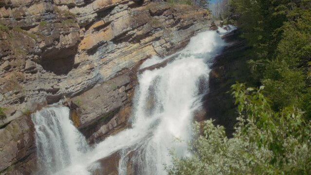 Cameron Falls lit by sunlight in Waterton National Park, Canada. Slow motion.
