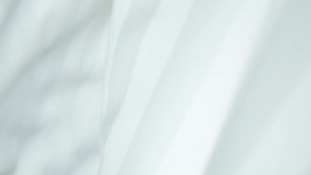Beautiful moving background of light milky color, waves on fabric