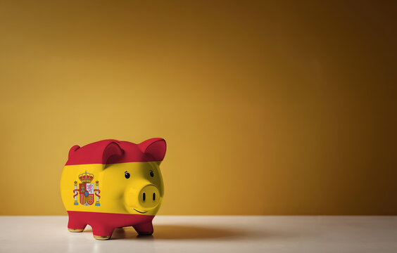 Piggy bank with painting of Spain flag. The problem is in the economy. Economic crisis. Saving money concept.