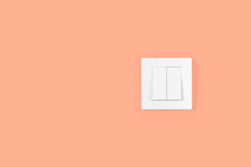 Light switch on orange peach wall. Electricity and light symbol.