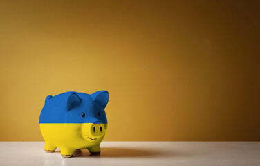 Piggy bank with painting of Ukraine flag. The problem is in the economy. Economic crisis. Saving money concept.