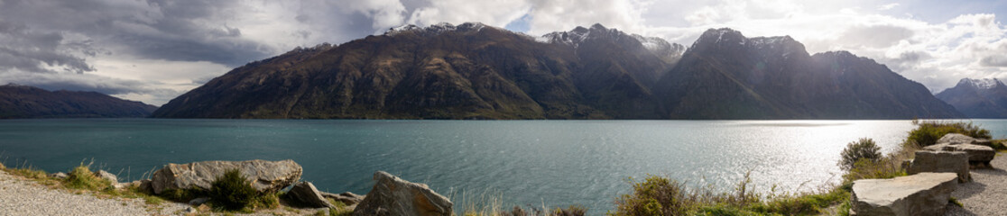 panoramic of lake with mountain and storm clouds in new zealand