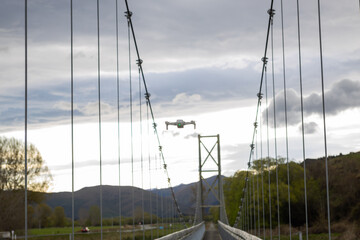 drone flying over mataura river bridge in new zealand