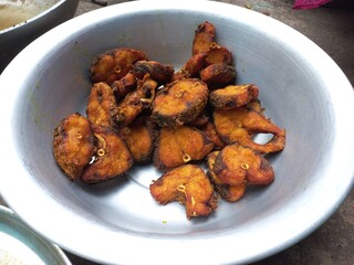 Dry tarmerik salt masala fish fry is a simple tasty delicious and flavourful fish fry in Aluminum pot,Hot Fried Fish on a Almuniyam container with Hot Oil,Hot bubbly and so delicious Fish,brown Fish 