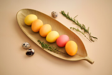 Easter eggs in pink, yellow and orange shades on a beige background.