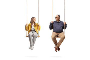 Mature man and a teenage girl sitting on swings and looking at each other