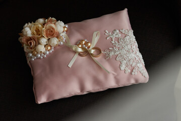 Closeup of a ring pillow with floral arrangement